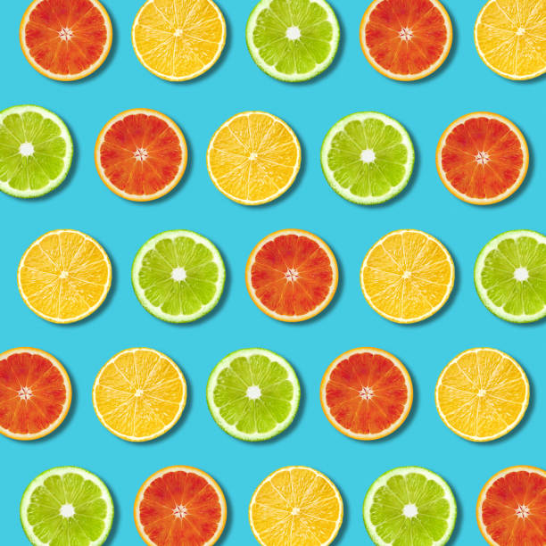 istock Multicolored vibrant citrus fruit slices texture on turquoise background 1130738098