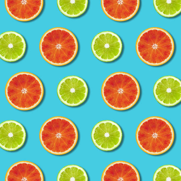 istock Vibrant red orange and green lime lemon slices pattern on turquoise background 1130738122