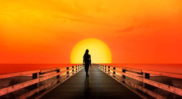 istock Woman walking into sunset 1130738170