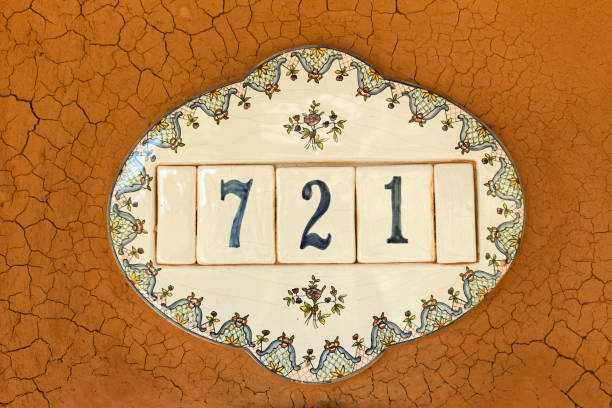 Plate with house number with mud wall.