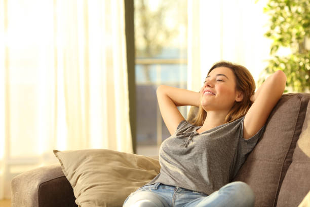donna felice che riposa comodamente a casa - comfortably foto e immagini stock