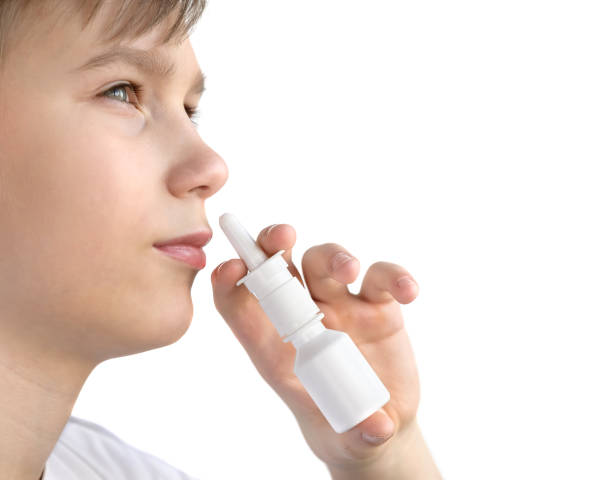 istock A boy using nasal spray isolated on a white background 1130739460