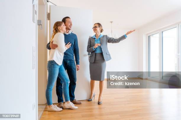 Real Estate Agent Showing House To A Young Couple Stock Photo - Download Image Now - Real Estate Agent, Apartment, Exploration