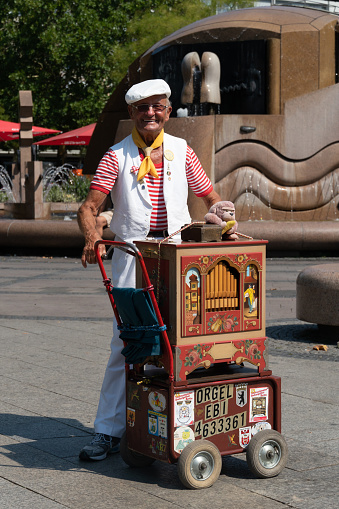 Berlin, Germany - August 16, 2018: Organ grinder, busker playing barrel organ