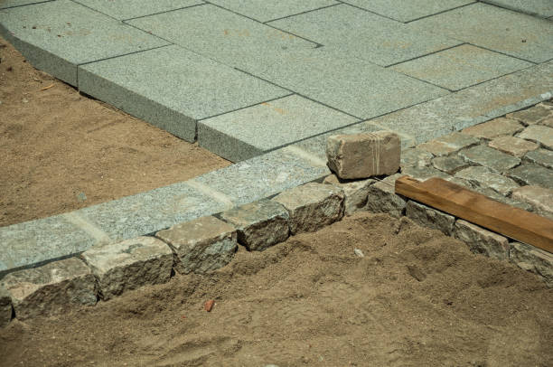istock Stone setts blocks being sand-seated in a construction site 1130745429