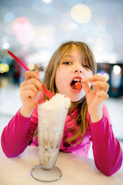 istock Beautiful child enjoying an ice cream or a milkshake 1130745609