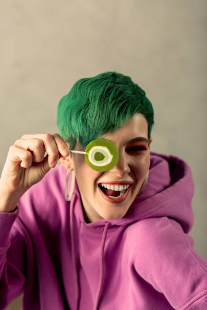 istock Cheerful green haired woman playing with a candy 1130746578