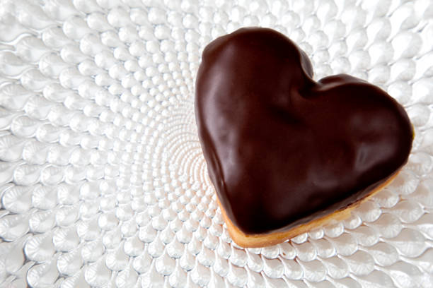 heart shape valentine doughnut with chocolate icing on a fancy plate - valentines day candy chocolate candy heart shape imagens e fotografias de stock