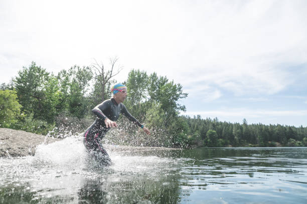 istock Female triathlete rushes into the water 1130750871