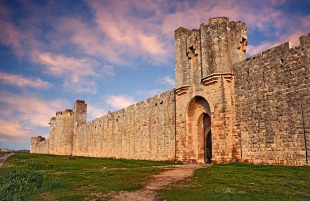 Aigues-Mortes, Gard, France: the medieval city walls of the town of Camargue Aigues-Mortes, Gard, Occitania, France: landscape at dawn with the medieval city walls of the town of Camargue city gate stock pictures, royalty-free photos & images