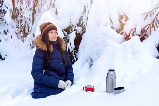istock girl drinks coffee from a thermos while walking through a snowy winter forest 1130751848