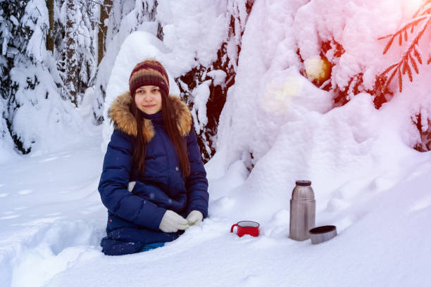 istock girl drinks coffee from a thermos while walking through a snowy winter forest 1130751850