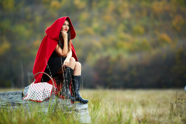 Woman dressed as Red Riding Hood in various postures in the forest