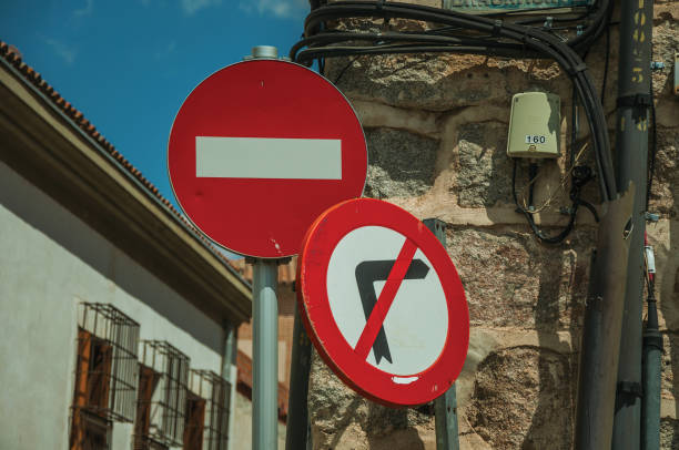 signalisation en face de la maison en pierre à avila - curve road in front of sign photos et images de collection