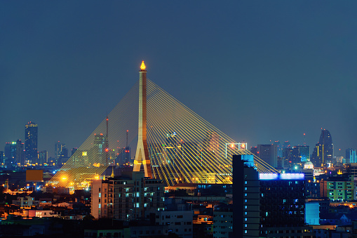 Rama 8 Bridge and Chao Phraya River in structure of suspension architecture concept, Urban city, Bangkok, Thailand. Downtown area at night, Thailand.