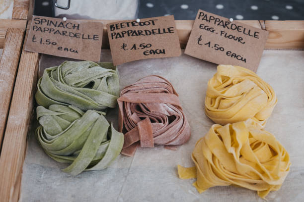 Fresh artisan pappardelle pasta on sale at a market. Variety of fresh artisan pappardelle pasta on sale at a street market. spinach pasta stock pictures, royalty-free photos & images