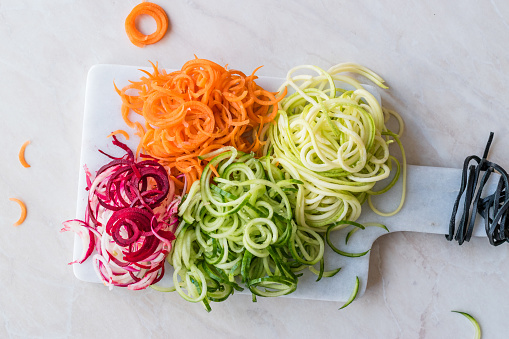 Spiralized Vegetables Noodle Carrot, Beetroot, Zucchini and Cucumber on Marble Board. Organic Food.