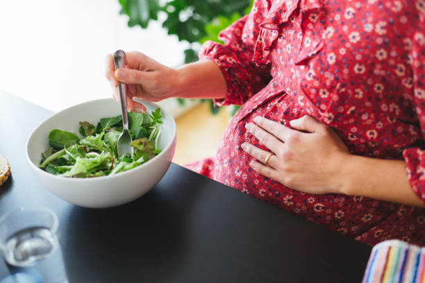 Healthy pregnant woman eating a salad - fotografia de stock