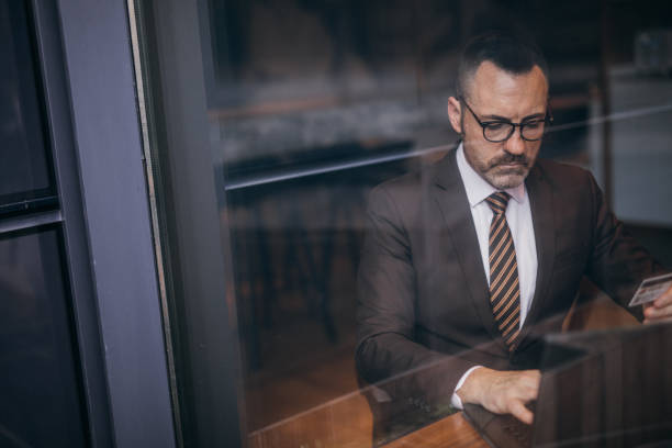 istock Senior man in suit paying online 1130755907