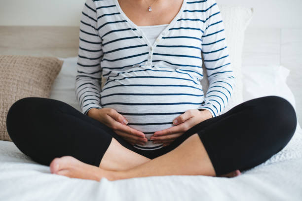 mujer embarazada relajante en la cama - human pregnancy yoga exercising prenatal care fotografías e imágenes de stock