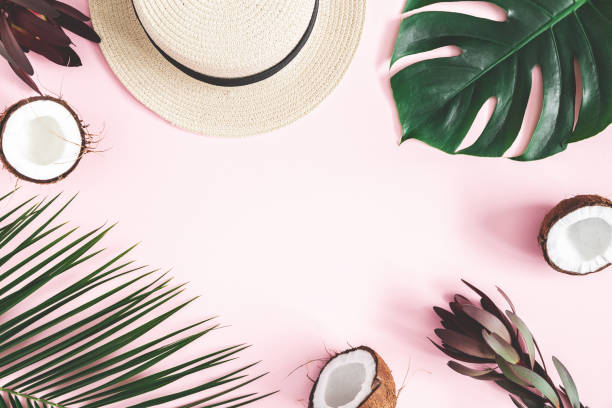 istock Summer composition. Tropical palm leaves, hat, coconut on pastel pink background. Summer concept. Flat lay, top view, copy space 1130756301
