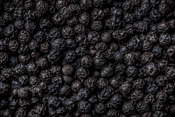 istock Black pepper large overhead close up arrangement on dark background 1130757116