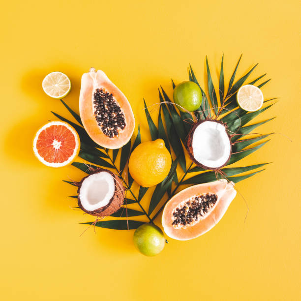 frutas y hojas de palma sobre fondo amarillo. frutas tropicales. concepto de verano. lay plano, vista superior, cuadrado - fruta tropical fotografías e imágenes de stock