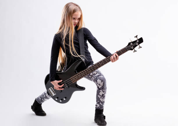 blonde fille aux cheveux longs est un joueur de basse guitare - bass photos et images de collection