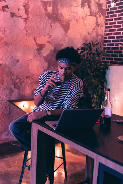 istock Young man drinking wine while celebrating his birthday with online friend. 1130760584