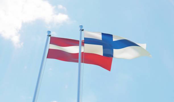 istock Latvia and Finland, two flags waving against blue sky 1130761059