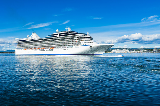 A big cruise ship overtaken by a speedboat in Oslo fjord. Oslo, Norway, August 2018