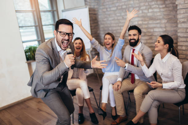istock Business people singing karaoke in modern office 1130761639