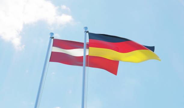 istock Latvia and Germany, two flags waving against blue sky 1130761711