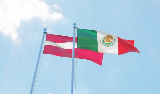istock Latvia and Mexico, two flags waving against blue sky 1130761831