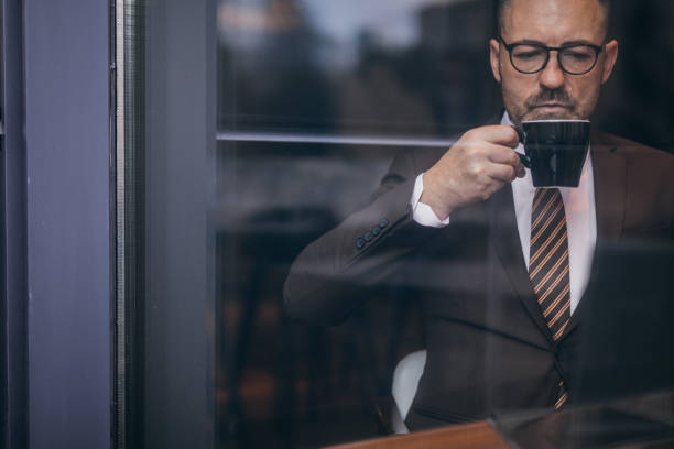 istock Senior man in suit drinking coffee 1130763360