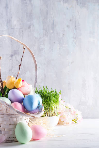 istock Easter basket filled with colorful hand painted Easter Eggs over a light background 1130763675