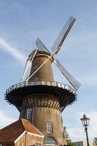 istock Molen De Valk windmill at Leiden, Netherlands. Sunny day and sky with clouds. 1130768898