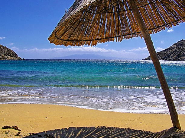Straw umbrella on a sandy beach, Mykonos Greece