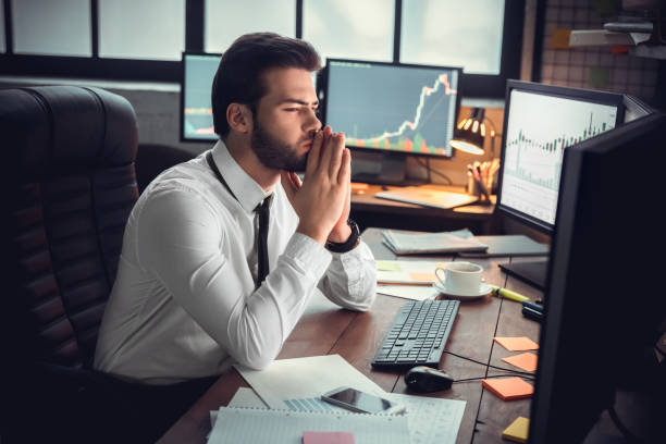 istock Young male trader at office work concept sitting looking at monitors thoughtful 1130771078