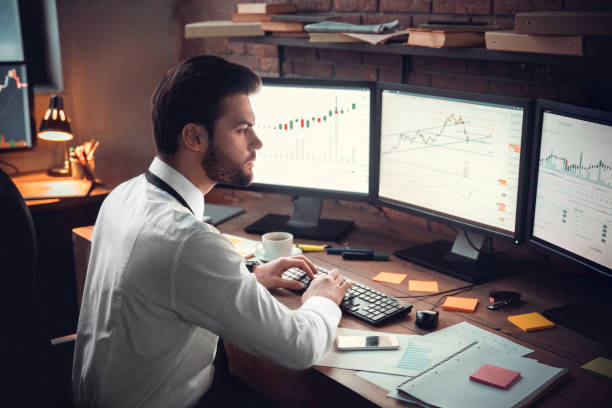 istock Young male trader at office work concept sitting typing on keyboard 1130771082