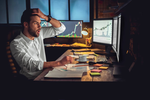 istock Young male trader at office work concept sitting looking at computer disappointed 1130771144