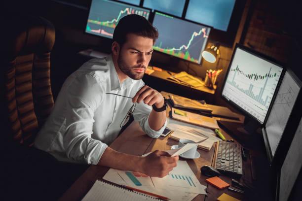 istock Young male trader at office work concept sitting looking at screen thoughtful 1130771149