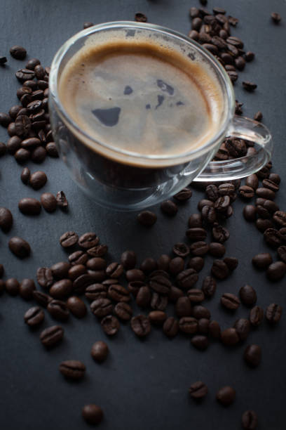 coffee cup with fresh brewed coffee and brown roasted coffee beans - koffie imagens e fotografias de stock