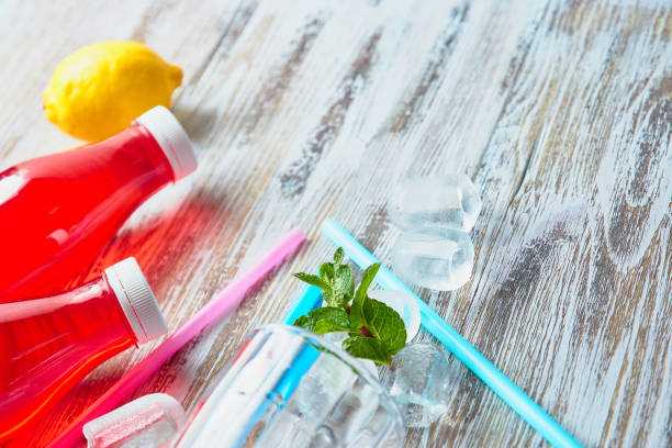 istock plastic bottles with berries, refreshing drink. scattered ice cubes and drinking straws. on the background of a shabby wooden table. close up. copy space. 1130779018
