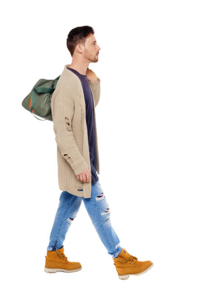 istock back view of walking  man  with green bag. 1130780158