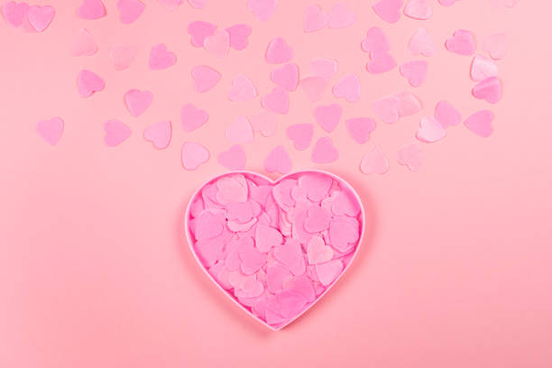 istock Pink heart-shaped box full of confetti hearts. 1130780195