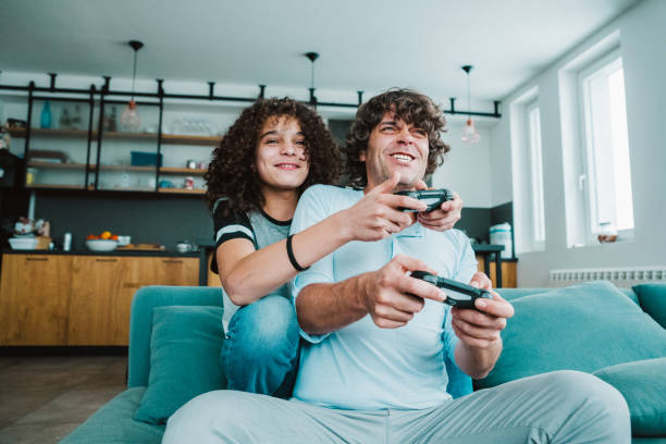 Father and son playing digital games at home