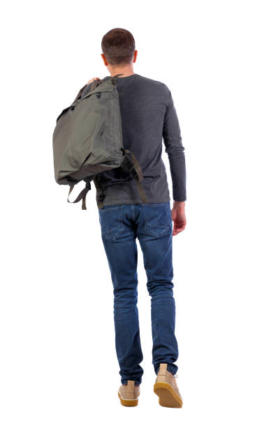 istock back view of walking  man  with green bag. 1130783981