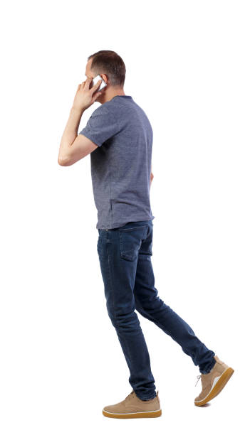 istock a side view of man walking with a mobile phone. 1130785412