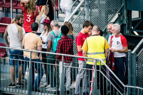 Sports fans walking onto stadium bleachers Sports fans walking up the stairs past a security guard onto the bleachers of a stadium. sports event stock pictures, royalty-free photos & images